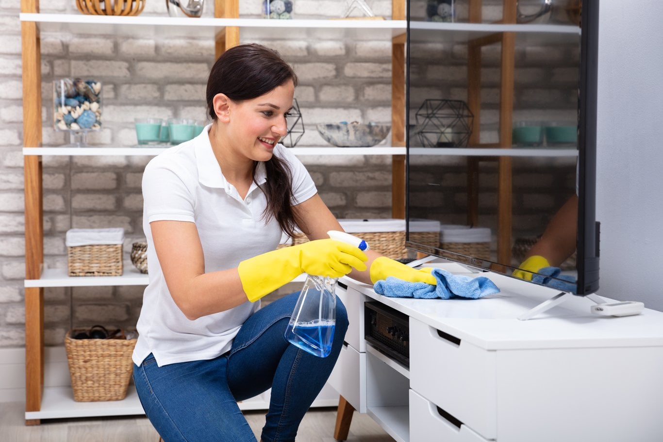 House cleaner wiping tv unit